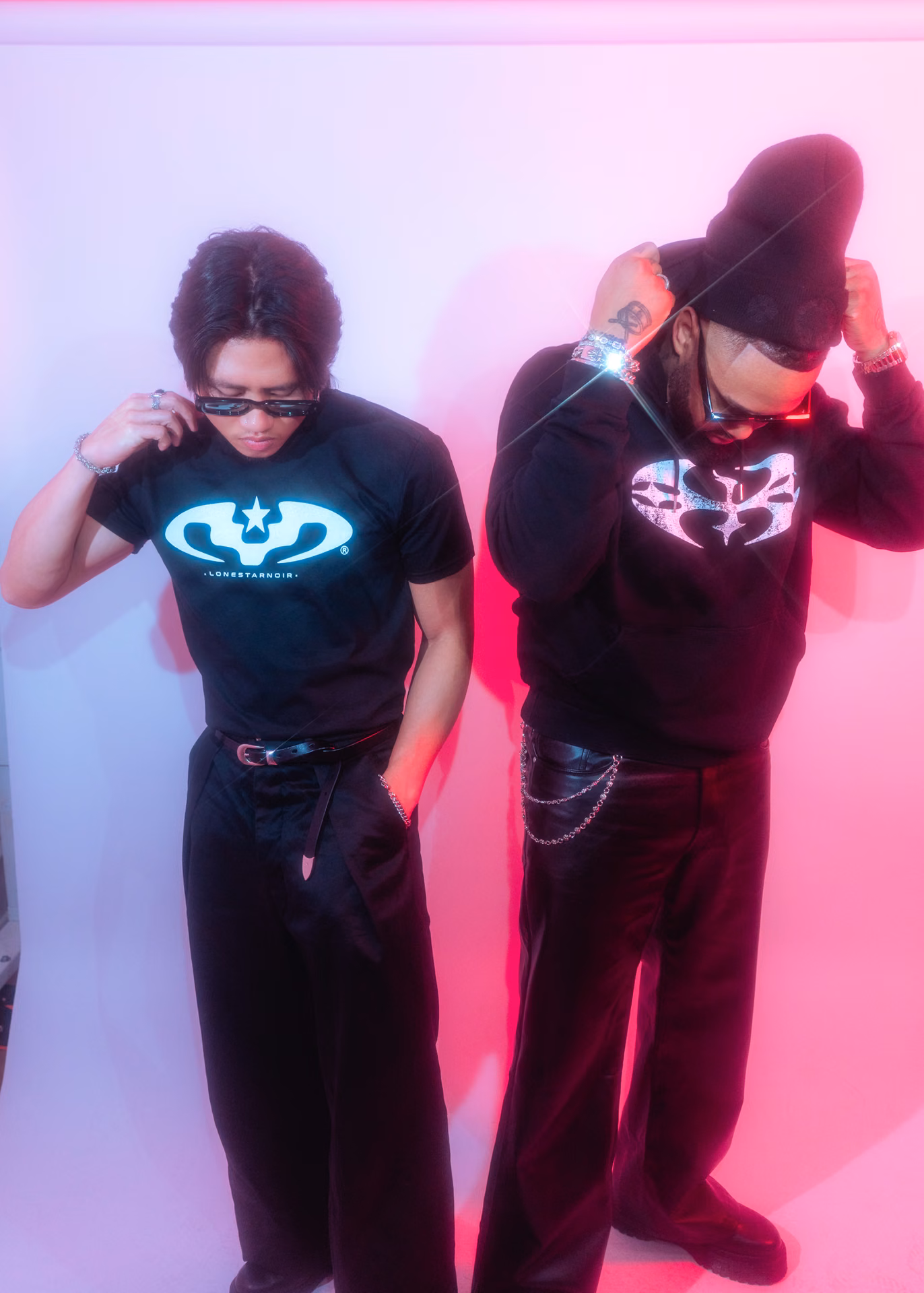A two-up lookbook frame in saturated pink: a Lone Star Noir tee, a longhorn-banded cowboy hat, peace signs thrown into colored gel. Streetwear shot like a record cover.