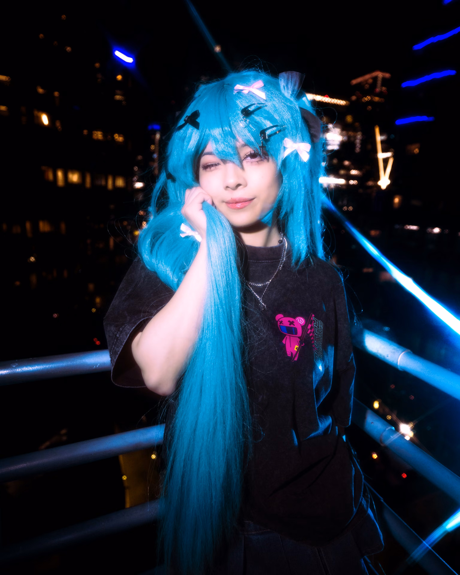 Hatsune Miku caught mid-jump on a rooftop, teal twin-tails flying over a streak of city light; Davila freezes the energy at the very top of the leap.
